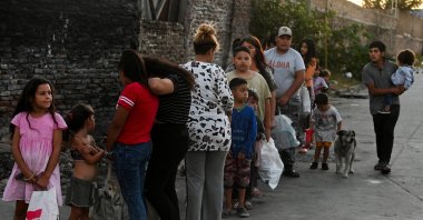 People wait in line outside a soup kitchen to receive a ration of stew, in the working-class neighborhood Villa Fiorito, on the outskirts of Buenos Aires, Argentina, Feb. 13, 2024. (Reuters Photo)