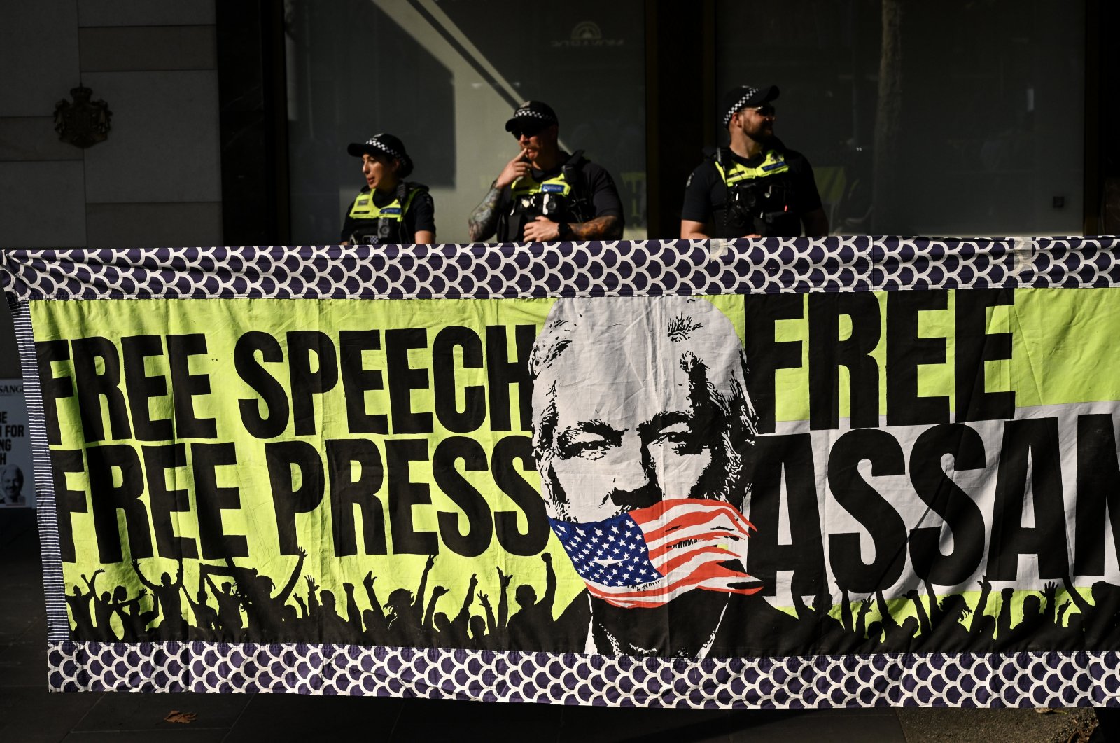 Victorian Police officers stand behind a banner at a 24-hour vigil for Julian Assange in Melbourne, Australia, Feb. 20, 2024. (EPA Photo)