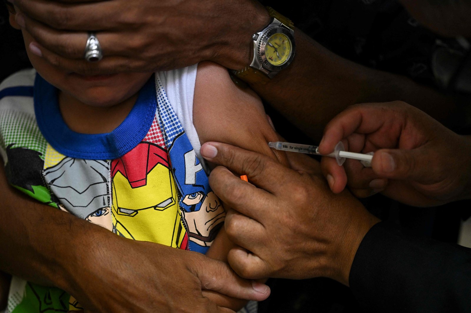 A boy accompanied by his father receives a dose of the measles and rubella vaccine in Caracas, Venezuela, Aug. 17, 2022. (AFP Photo)