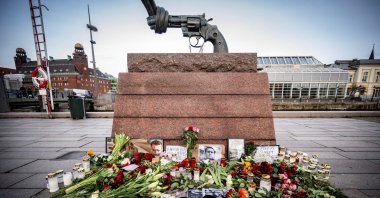 Flowers, lights and portraits sit at the memorial site for Alexei Navalny at Carl Fredrik Reutersward's sculpture "Non-Violence," at Anna Lindhs Place, in Malmo, Sweden, Feb. 20, 2024. (Reuters Photo)