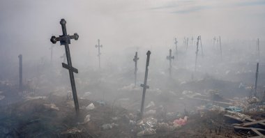 Crosses are seen through smoke at a cemetery in Mykolaiv, southern Ukraine, March 21, 2022. (AFP Photo)