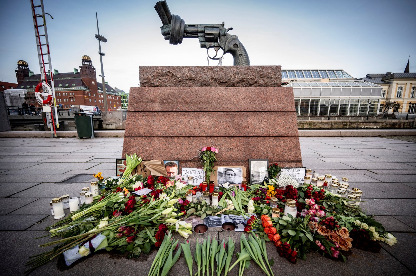 Flowers, lights and portraits sit at the memorial site for Alexei Navalny at Carl Fredrik Reutersward&#039;s sculpture &quot;Non-Violence,&quot; at Anna Lindhs Place, in Malmo, Sweden, Feb. 20, 2024. (Reuters Photo)