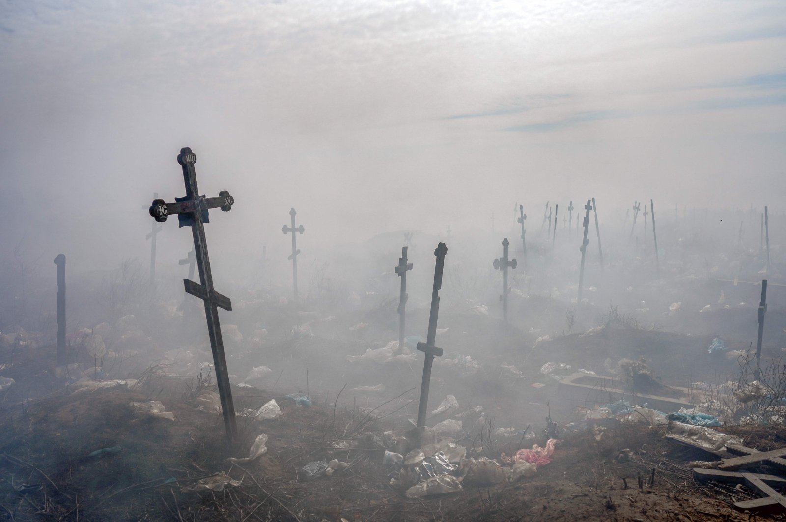Crosses are seen through smoke at a cemetery in Mykolaiv, southern Ukraine, March 21, 2022. (AFP Photo)