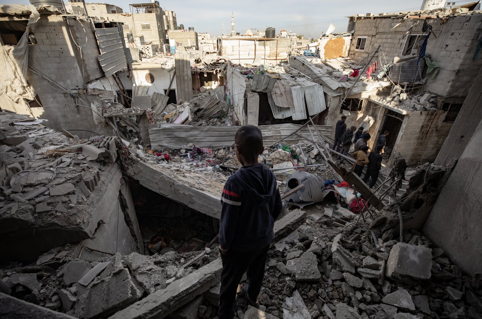 A child looks on as Palestinians inspect a destroyed area following an Israeli airstrike on the Rafah refugee camp, southern Gaza Strip, Feb. 12, 2024. (EPA Photo)