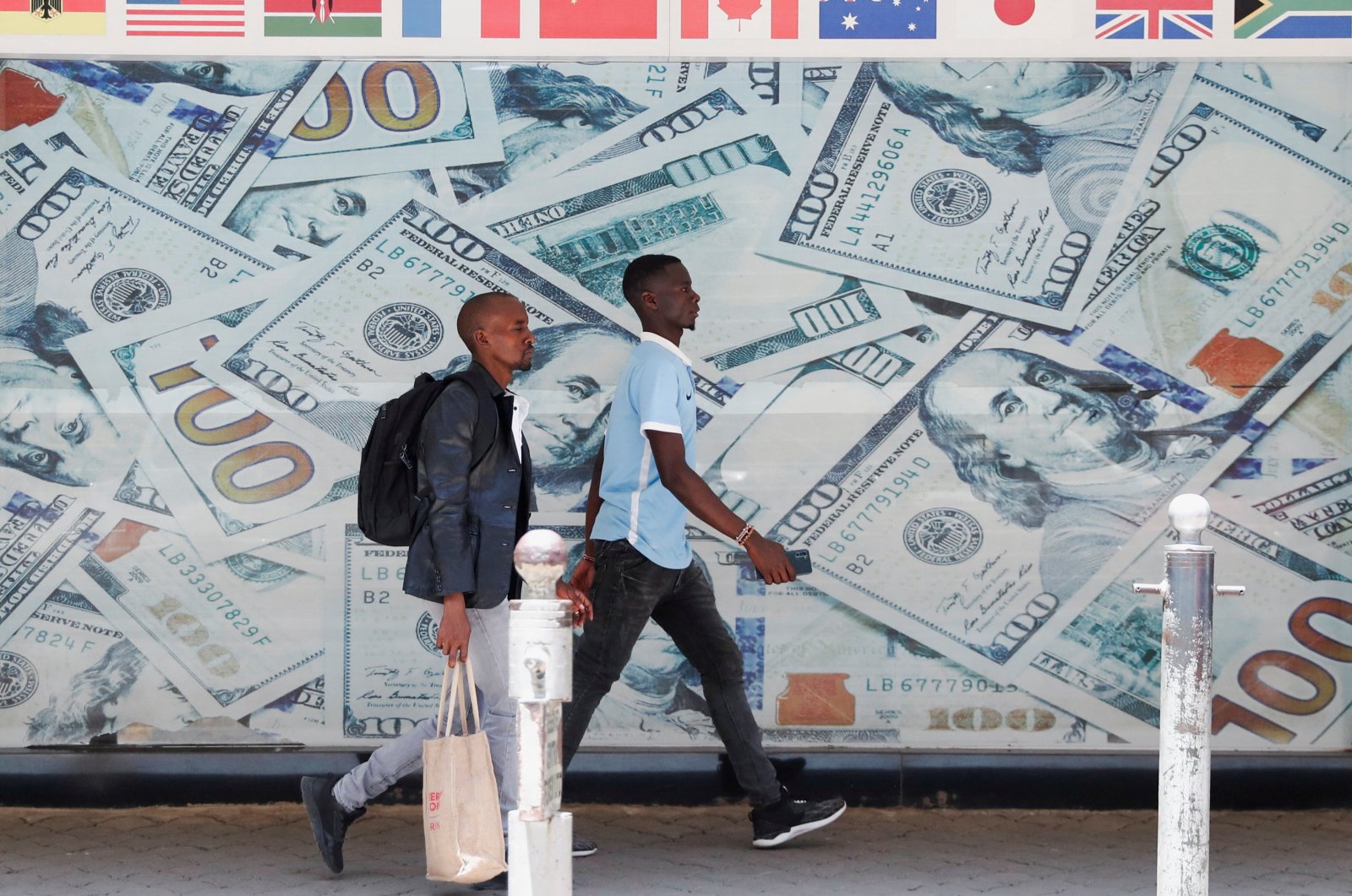 People walk past an image of U.S. dollar bills outside a currency exchange bureau in downtown Nairobi, Kenya, Feb. 16, 2024. (Reuters Photo)