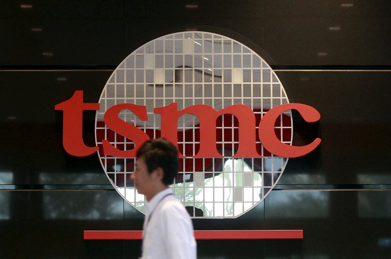 An employee walks in front of the logo of Taiwan Semiconductor Manufacturing Company (TSMC) at its headquarters in Hsinchu, northern Taiwan, Nov. 19, 2015. (Reuters Photo)