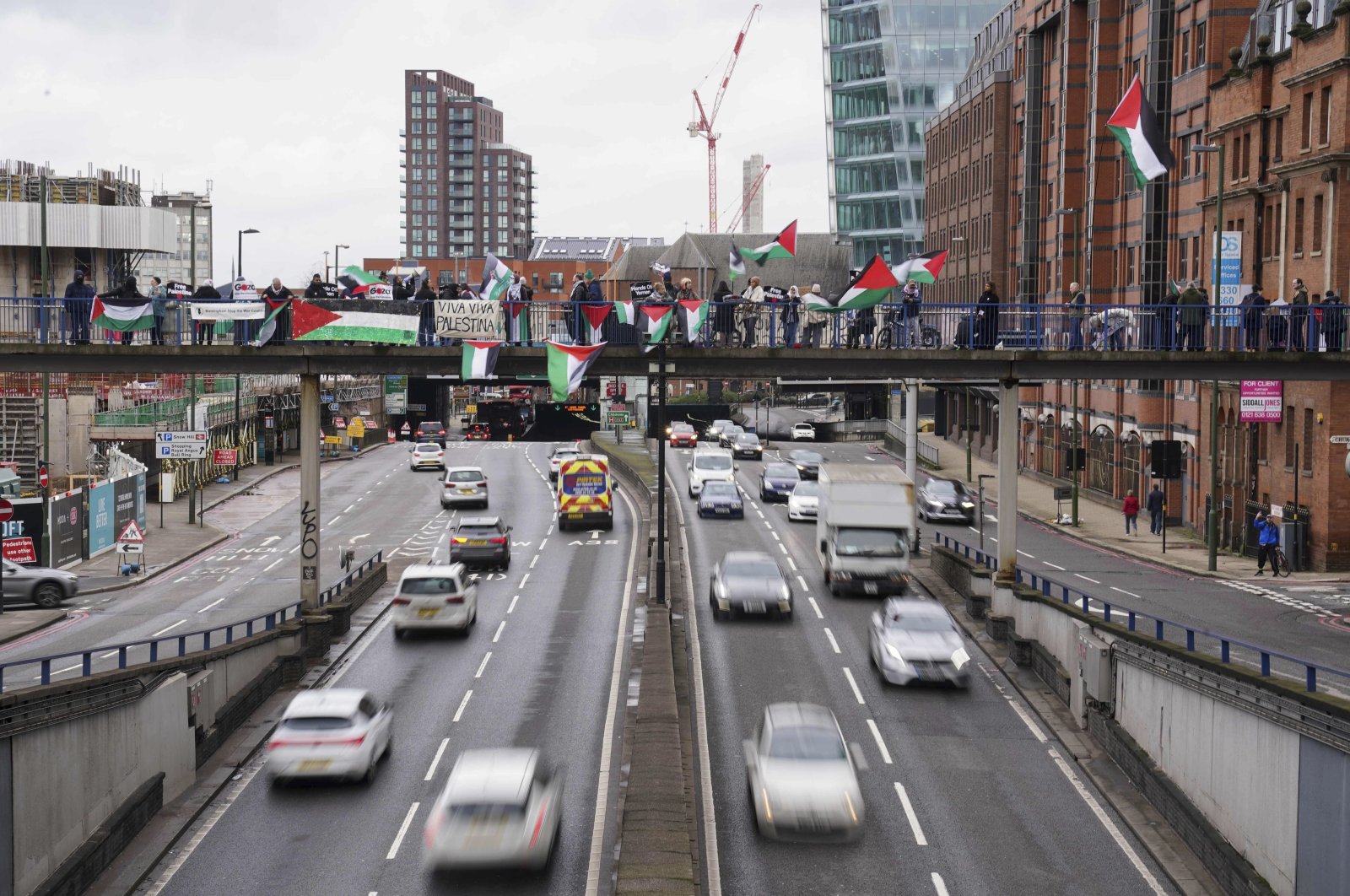 People take part in a pro-Palestinian protest on a bridge over the Queensway in central Birmingham, England, Sunday, Feb. 18, 2024. (Jacob King/PA via AP)