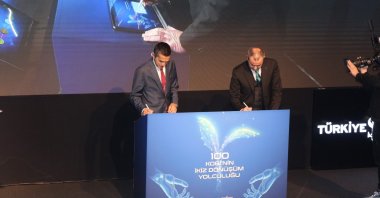 Özgür Burak Akkol (L), head of MESS, and Hakan Aran, general manager of Işbank, sign an agreement, Istanbul, Türkiye, Feb. 21, 2024. (IHA Photo)