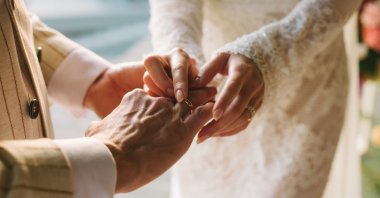A bride putting a wedding ring on the groom's finger, Feb. 23, 2024. (Getty Images)
