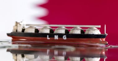 A model of an LNG tanker is seen in front of Qatar&#039;s flag in this illustration taken May 19, 2022. (Reuters Photo)