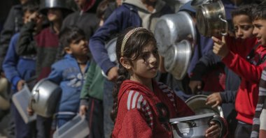 Internally displaced Palestinian children line up with their pots and containers waiting to receive food provided by Arab and Palestinian donors in Deir al-Balah, southern Gaza Strip, Palestine, Feb. 24, 2024. (EPA Photo)