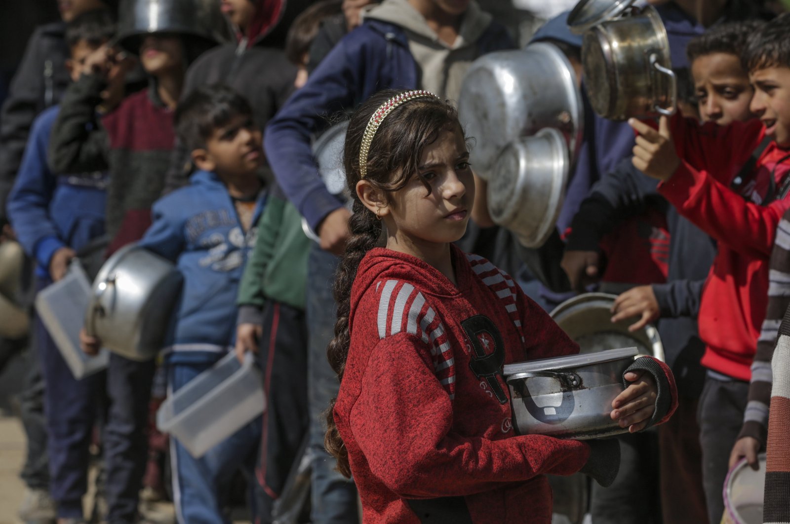 Internally displaced Palestinian children line up with their pots and containers waiting to receive food provided by Arab and Palestinian donors in Deir al-Balah, southern Gaza Strip, Palestine, Feb. 24, 2024. (EPA Photo)