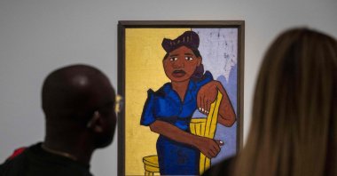 People look at a painting by William H. Johnson titled &quot;Woman in Blue&quot;  during a press preview of &quot;The Harlem Renaissance and Transatlantic Modernism” exhibition at the Metropolitan Museum of Art in New York City, U.S., Feb. 20, 2024. (AFP Photo)