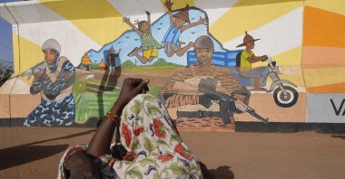 A woman looks at a mural in Ouagadougou, Burkina Faso, March 1, 2023. (AP Photo)