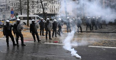 Belgian riot police officers stand guard as gas leaks from a tear gas against the European Agriculture Council, Brussels, Belgium, Feb. 26, 2024. (AFP Photo)