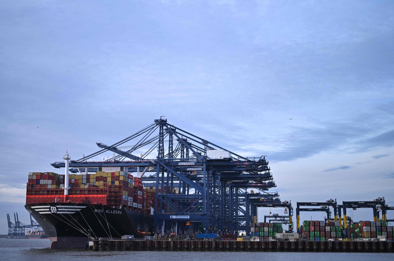 Stacks of containers are pictured on the deck of the MSC Allegra container ship, docked beside container cranes at the U.K.&#039;s largest freight port, in Felixstowe on the East coast of England, Jan. 27, 2024. (AFP Photo)