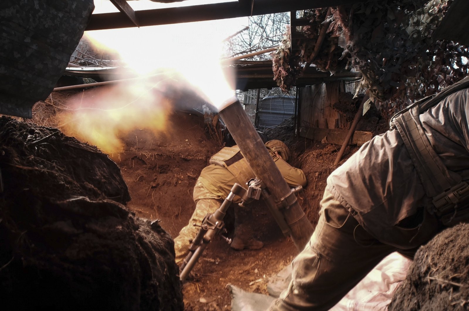 Ukrainian servicemen take cover as they shoot a mortar near Avdiivka, in the Donetsk area, Ukraine, Feb. 24, 2024. (EPA Photo)