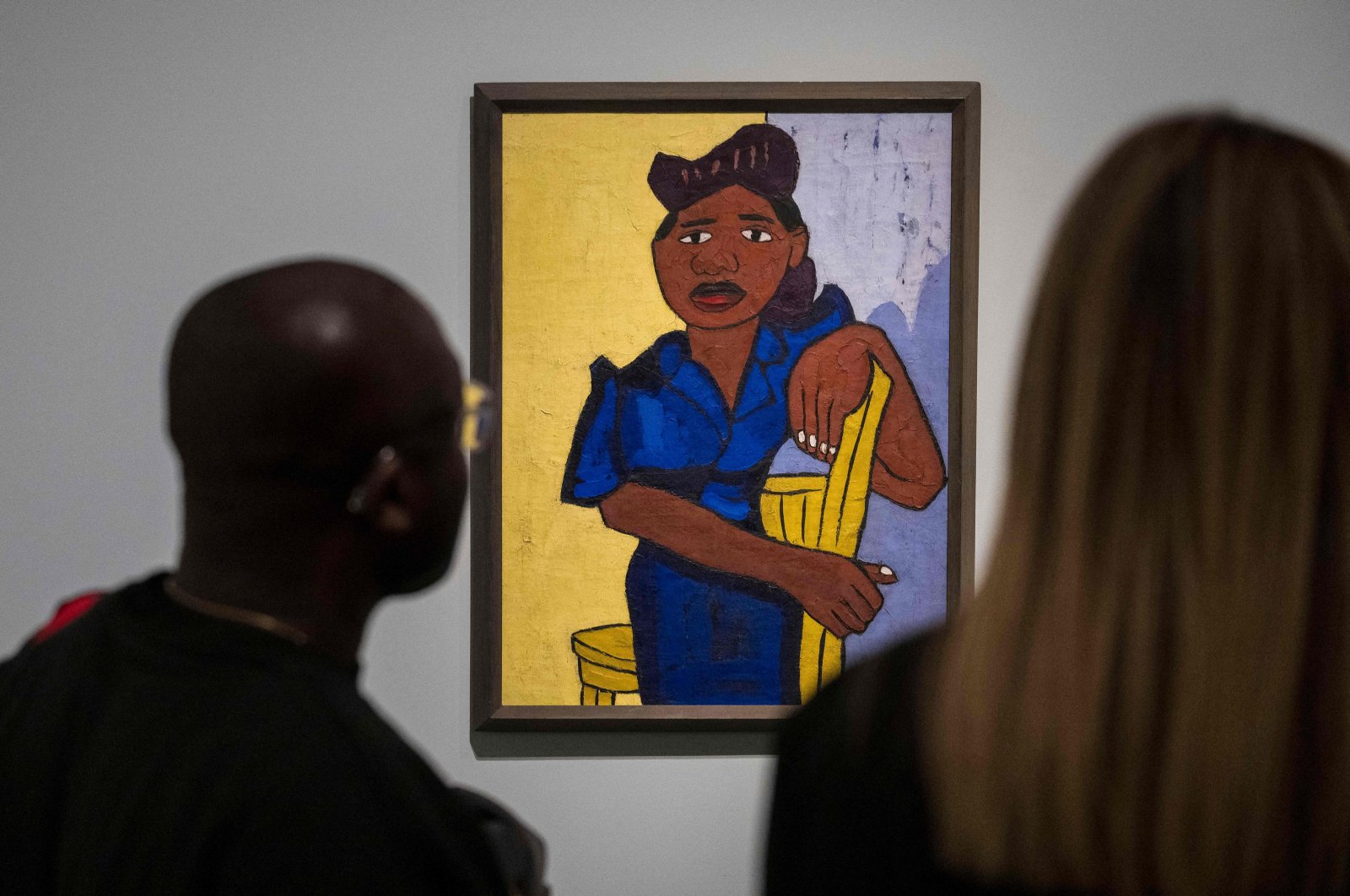 People look at a painting by William H. Johnson titled &quot;Woman in Blue&quot;  during a press preview of &quot;The Harlem Renaissance and Transatlantic Modernism” exhibition at the Metropolitan Museum of Art in New York City, U.S., Feb. 20, 2024. (AFP Photo)