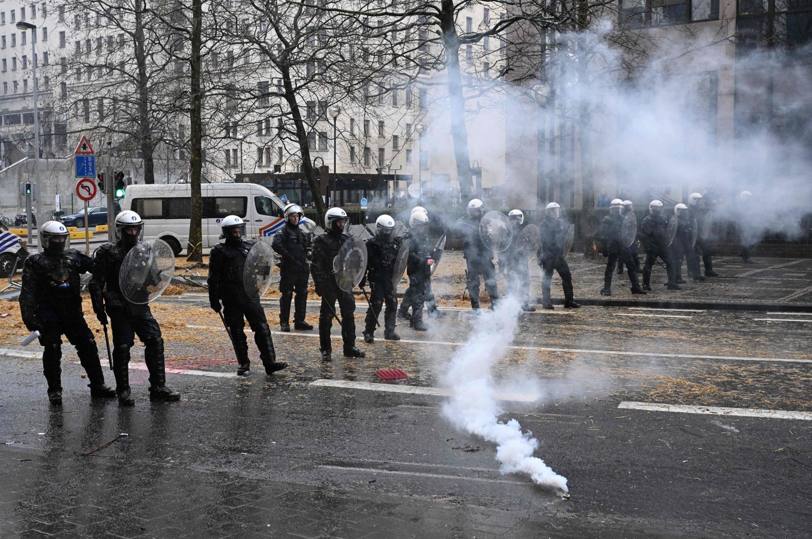Belgian riot police officers stand guard as gas leaks from a tear gas against the European Agriculture Council, Brussels, Belgium, Feb. 26, 2024. (AFP Photo)
