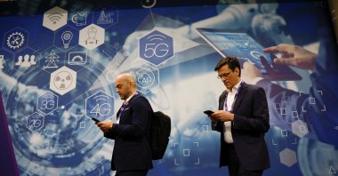 People walk by an advert for 5G at the 2024 Mobile World Congress (MWC), Barcelona, Spain, Feb. 27, 2024.