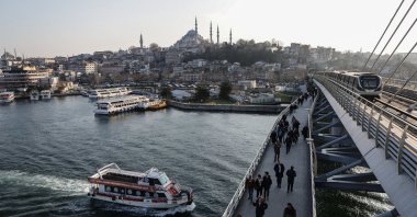 People walk on a bridge backdropped by the Süleymaniye Mosque in Istanbul, Türkiye, Feb. 21, 2024. (EPA Photo)