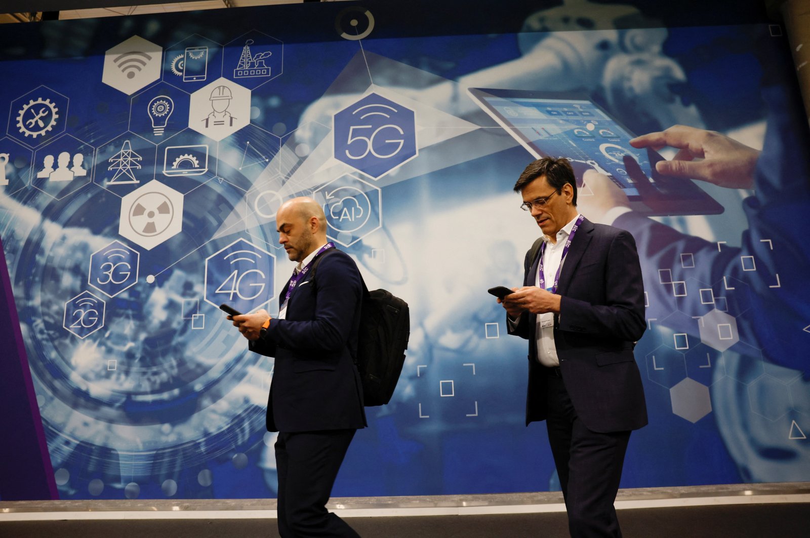 People walk by an advert for 5G at the 2024 Mobile World Congress (MWC), Barcelona, Spain, Feb. 27, 2024.