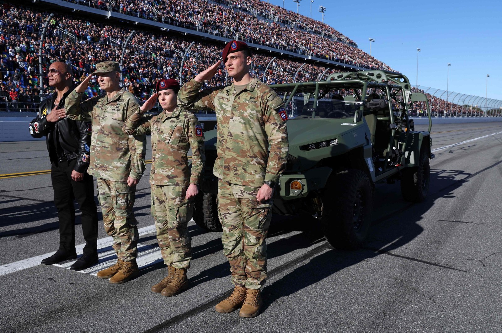 Dwayne &quot;The Rock” Johnson stands with U.S. Army service members during the national anthem before the NASCAR Cup Series Daytona 500, Daytona International Speedway, Daytona Beach, Florida, U.S., Feb. 19, 2024. (AFP Photo)