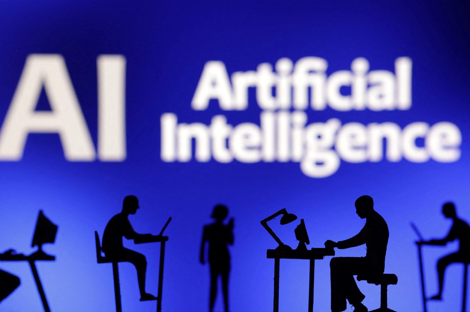 Figurines with computers and smartphones are seen in front of the words &quot;AI Artificial Intelligence&quot; in this illustration taken Feb. 19, 2024. (Reuters Photo)