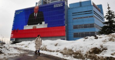 A woman walks past a screen displaying a broadcasting of Russia&#039;s President Vladimir Putin&#039;s annual State of the Nation address on the facade of a building in Moscow, Russia, Feb. 29, 2024. (AFP Photo)