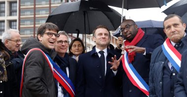 France&#039;s President Emmanuel Macron (center), surrounded by officials, during the inauguration of the Paris 2024 Olympic village in Saint-Denis, northern Paris, Feb. 29, 2024. (AFP Photo)