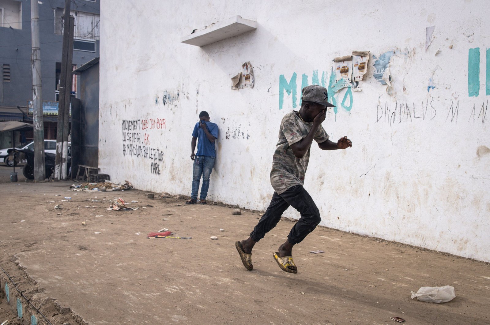 A protester runs from teargas during a march calling on authorities to respect the election date, in Dakar, Senegal, Feb. 16, 2024. (AFP Photo)