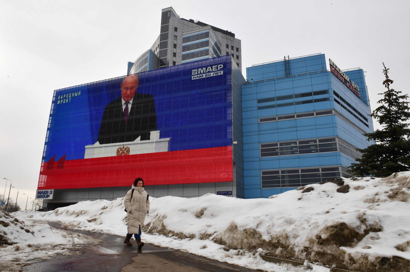 A woman walks past a screen displaying a broadcasting of Russia&#039;s President Vladimir Putin&#039;s annual State of the Nation address on the facade of a building in Moscow, Russia, Feb. 29, 2024. (AFP Photo)
