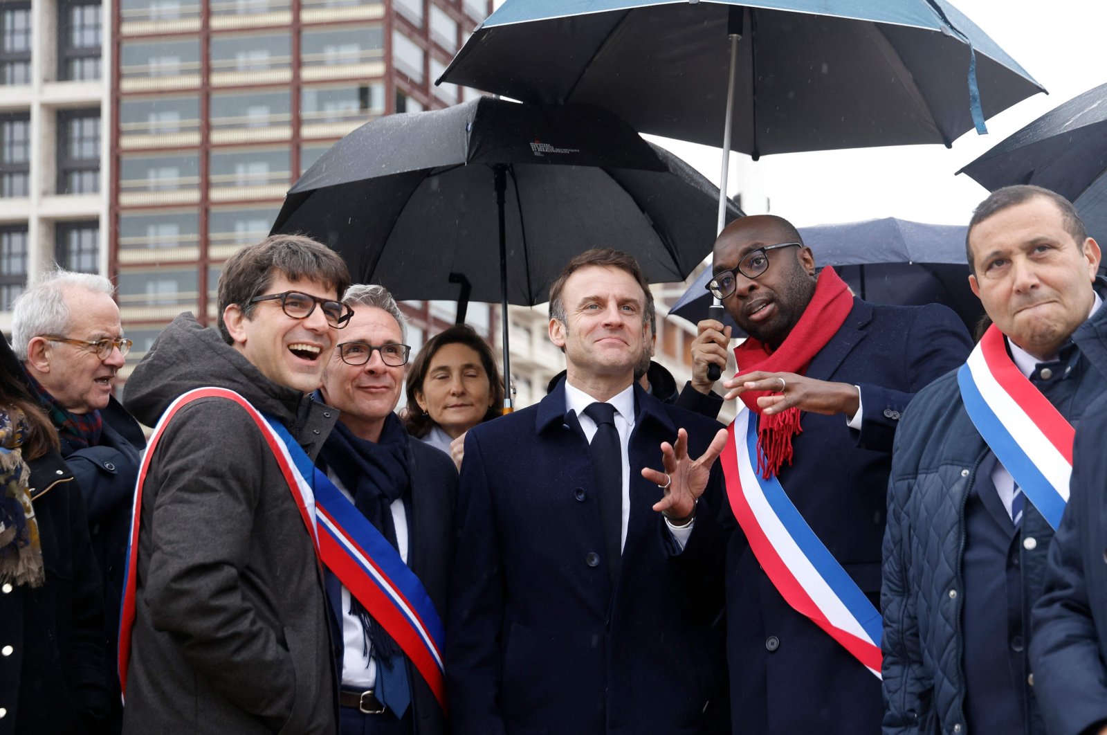 France&#039;s President Emmanuel Macron (center), surrounded by officials, during the inauguration of the Paris 2024 Olympic village in Saint-Denis, northern Paris, Feb. 29, 2024. (AFP Photo)