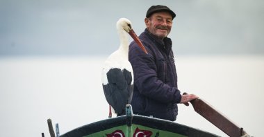The stork Yaren sits on the boat of fisherman Adem Yılmaz, known as &quot;Adem Uncle,&quot; in Karabacey, Bursa, northwestern Türkiye, Feb. 29, 2024. (AA Photo)