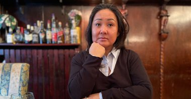 Danish adoptee 47-year old May-Britt Koed poses for a picture as her adoption files are seen on a table, Copenhagen, Denmark, Jan. 30, 2024. (AFP Photo)