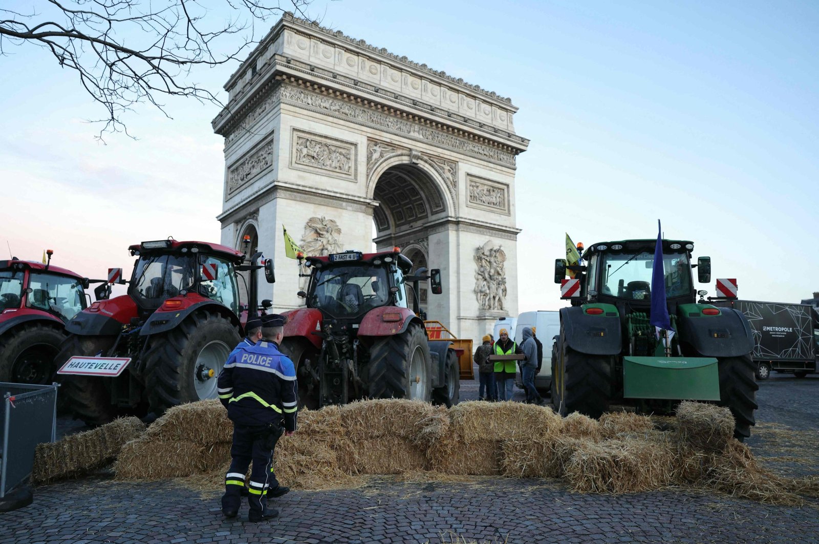 Police officers look at tractors parked next to the Arc de Triomphe on Champs-Elysees during a protest by the French farmers&#039; union, Paris, France, March 1, 2024. (AFP Photo)