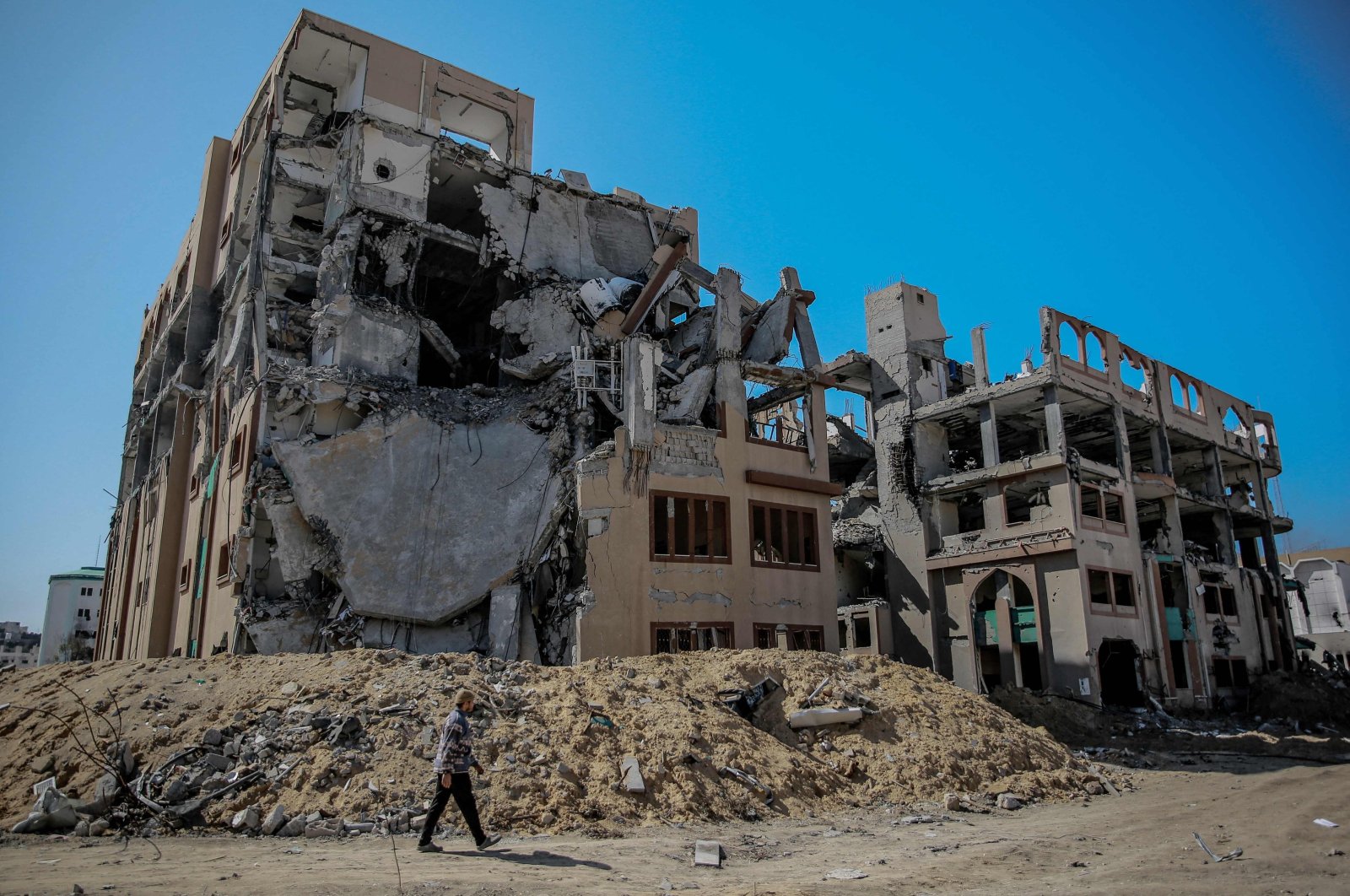 A Palestinian man walks past a heavily damaged building of Islamic University after an Israeli attack, Gaza City, Palestine, Feb. 15, 2024. (AFP Photo)