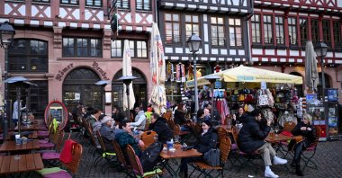 Customers sit at tables of a street cafe on the central Roemer Square in Frankfurt, Germany, Feb. 28, 2024. (AFP Photo)