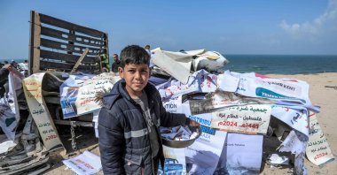 A boy walks past a truck carrying humanitarian aid that was hit by an Israeli airstrike on the main coastal road in Deir el-Balah, central Gaza Strip, Palestine, March 3, 2024. (AFP Photo)