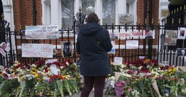 A person looks at flowers outside the Russian Embassy in London, on the day of the funeral of Russian opposition leader Alexei Navalny which took place in Moscow, Russia, Friday March 1, 2024. (AP Photo)