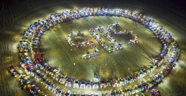 Farmers organize themselves to form a giant &quot;SOS&quot; signal with their tractors as coordinated stunt replicated in various locations across Switzerland, protesting against their work conditions and here specifically the price of milk, echoing numerous protests across Europe in the recents weeks, in a field between the villages of Echallens and Goumoens-la-Ville, Switzerland, Feb. 29, 2024. (AP Photo)