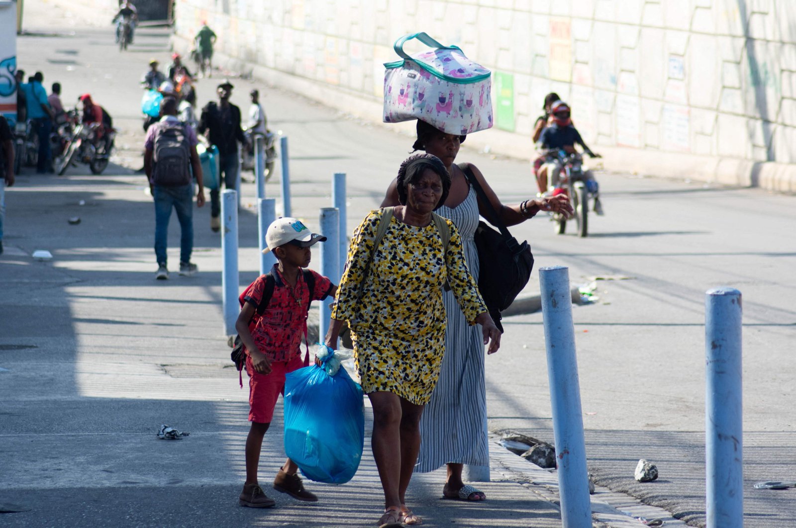 People living near the National Penitentiary, carry their belongings as they leave the area in Port-au-Prince, Haiti, March 4, 2024. (AFP Photo)