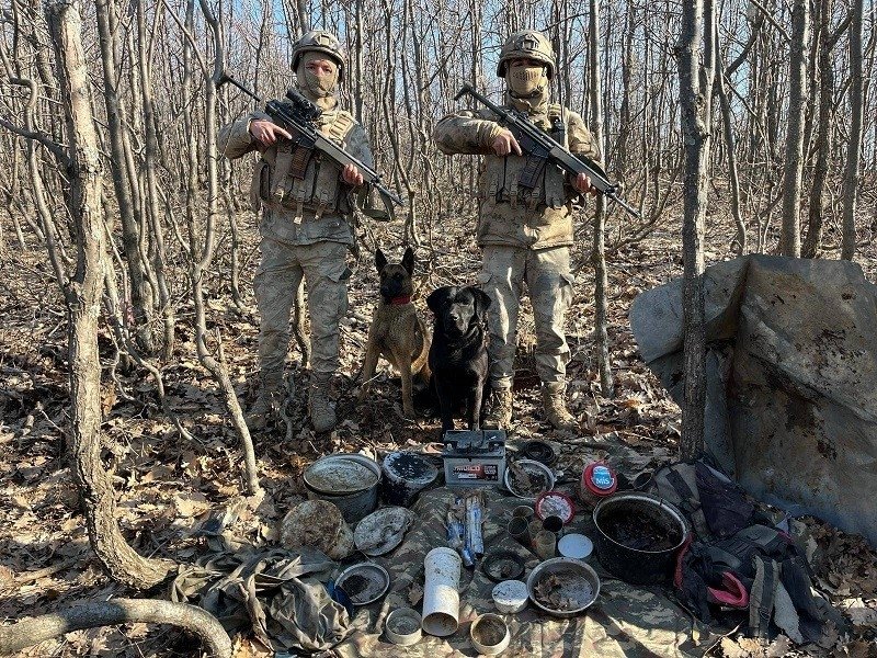 Two soldiers stand guard over materials seized in a PKK hideout in eastern Bingöl province, Türkiye, March 5, 2024. (IHA Photo)