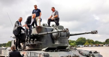 German Chancellor Olaf Scholz gets off a German self-propelled anti-aircraft gun Flakpanzer Gepard with head of training at arms manufacturer Krauss-Maffei Juergen Schoch and CEO of Nexter Defense Systems Frank Haun, during a visit of the training program for Ukrainian soldiers on the Gepard anti-aircraft tank in Putlos near Oldenburg, Germany, Aug. 25, 2022. (Reuters Photo)