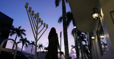 A woman walks past a menorah standing outside a Jewish synagogue ahead of the start of Hanukkah, in Miami Beach, Florida, U.S., Dec. 1, 2023. (AP Photo)