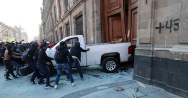 Demonstrators push a pickup truck to break down a presidential palace door in Mexico City, Mexico, March 6, 2024. (AFP Photo)