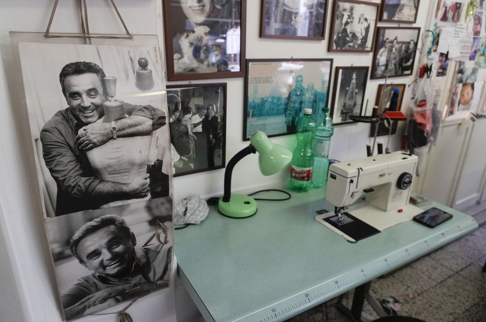 A picture of Umberto Tirelli (L) is displayed near a sewing machine at the Tirelli Atelier in Rome, Italy, March 5, 2024. (AP Photo)