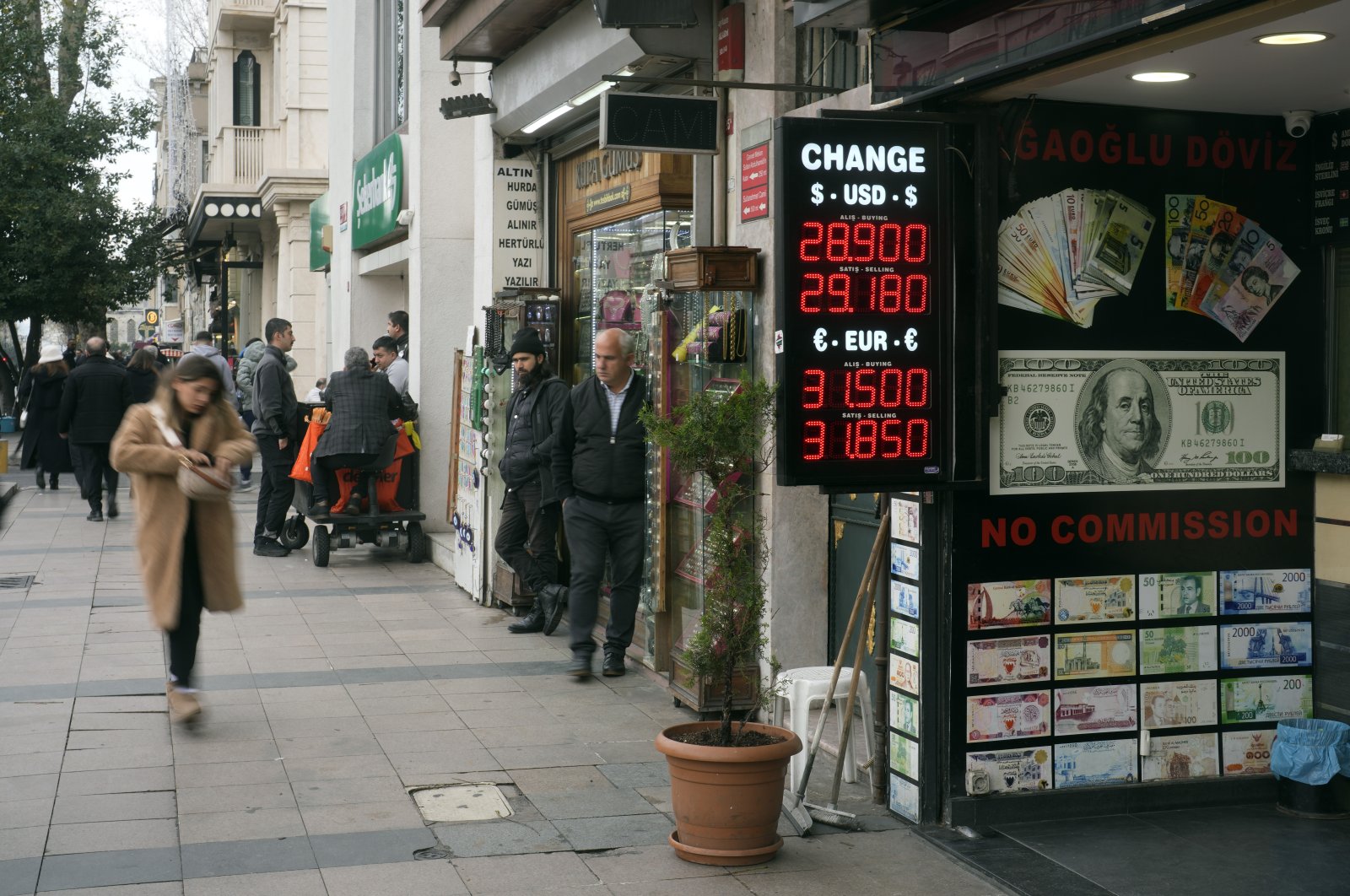 People walk next to an exchange currency shop in Istanbul, Türkiye, Dec. 21, 2023. (AP Photo)