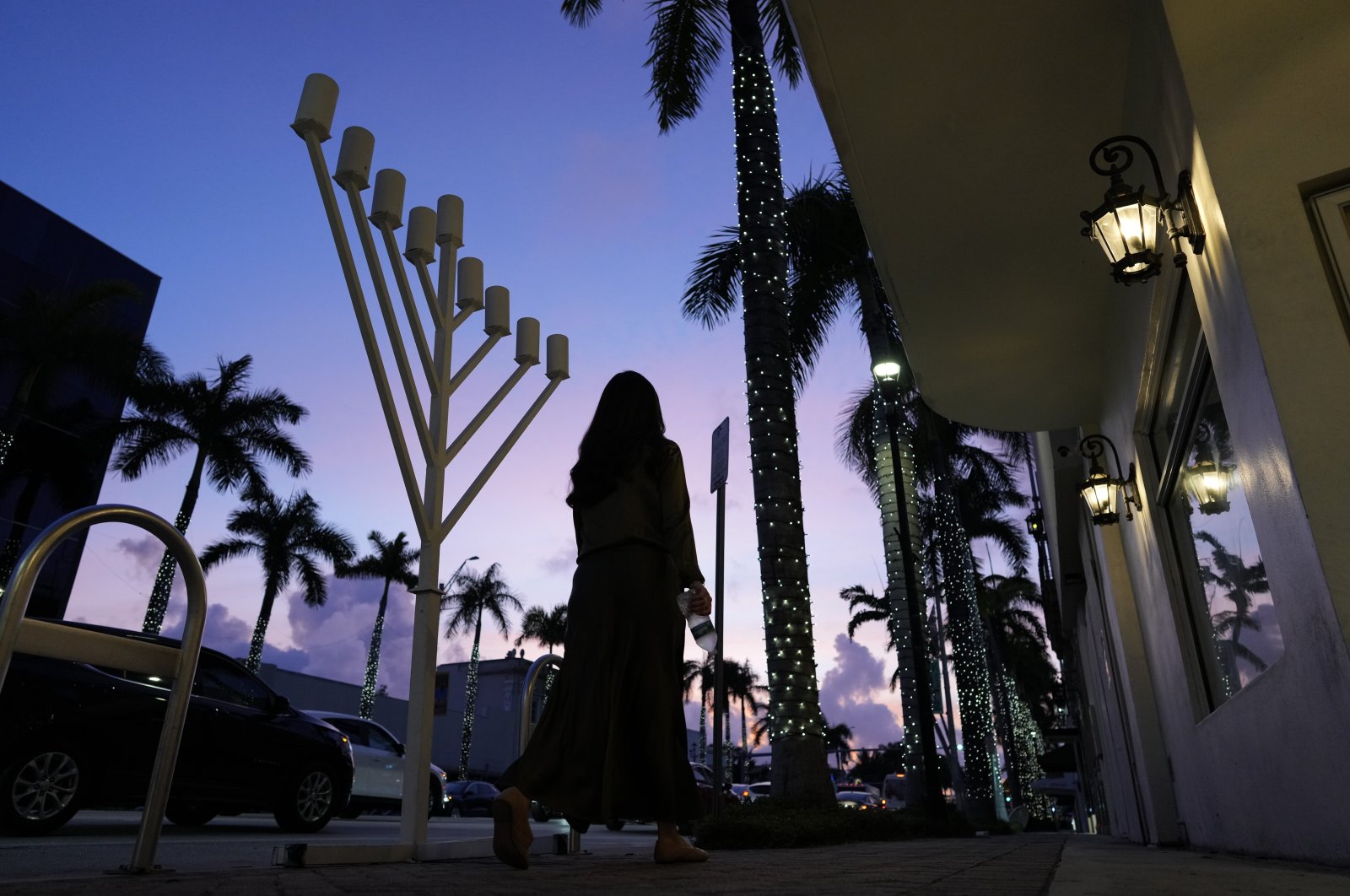 A woman walks past a menorah standing outside a Jewish synagogue ahead of the start of Hanukkah, in Miami Beach, Florida, U.S., Dec. 1, 2023. (AP Photo)