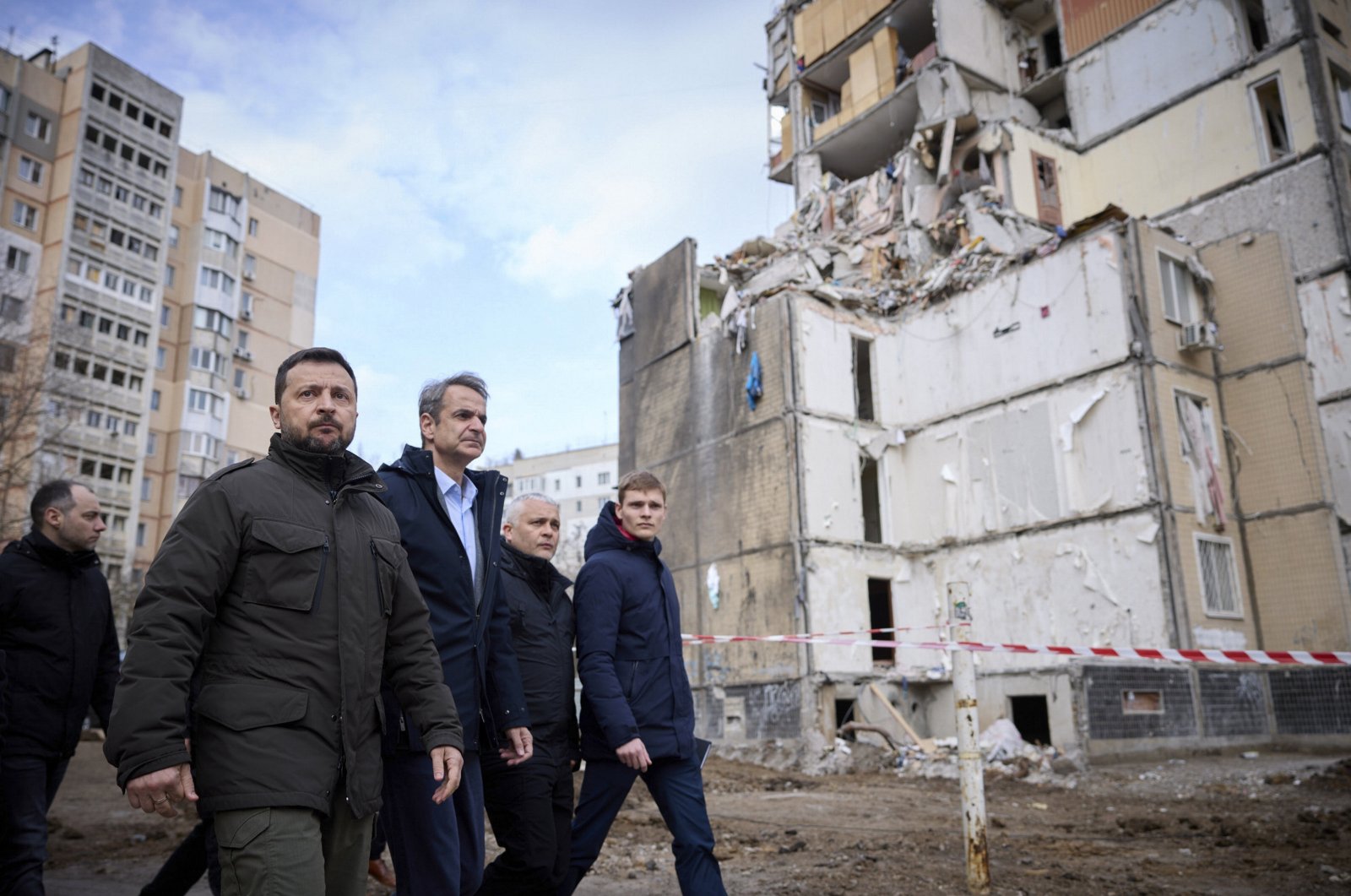 Ukrainian President Volodymyr Zelenskyy and Greek Prime Minister Kyriakos Mitsotakis walking in front of a damaged residential building at a site hit in a Russian drone attack in Odesa, Ukraine, March 6, 2024. (EPA via Ukraine Presidential Service)